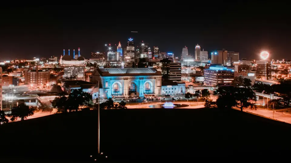 Downtown Kansas City at night, with Union Station lit blue in front of the skyline