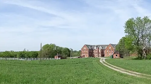 The brick Inn at Belvoir Winery across green fields in Liberty