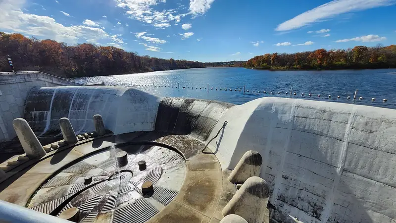 Lake Lenexa and its fall-colored shoreline, seen from the bridge over the stepped spillway