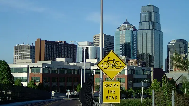 The Kansas City skyline behind a Share the Road sign near the Town of Kansas Bridge